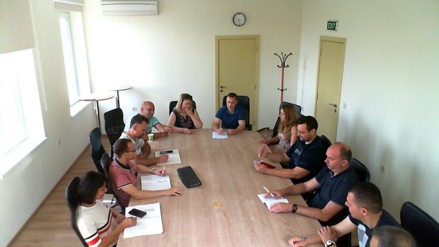 Meeting participants seated around a long conference table